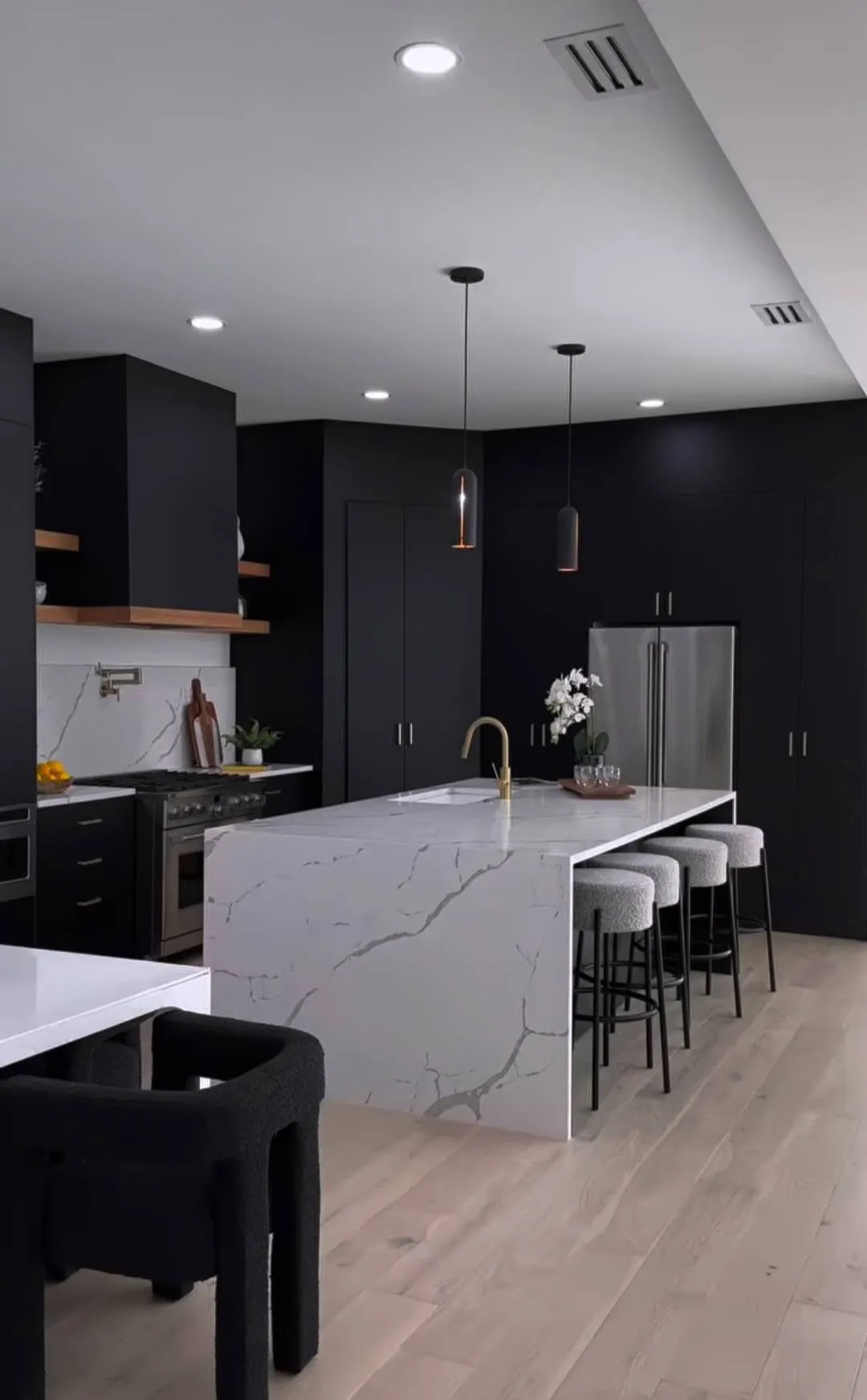 Black cabinet kitchen with a white quartz waterfall island, remodeled by OKC 405 Construction
