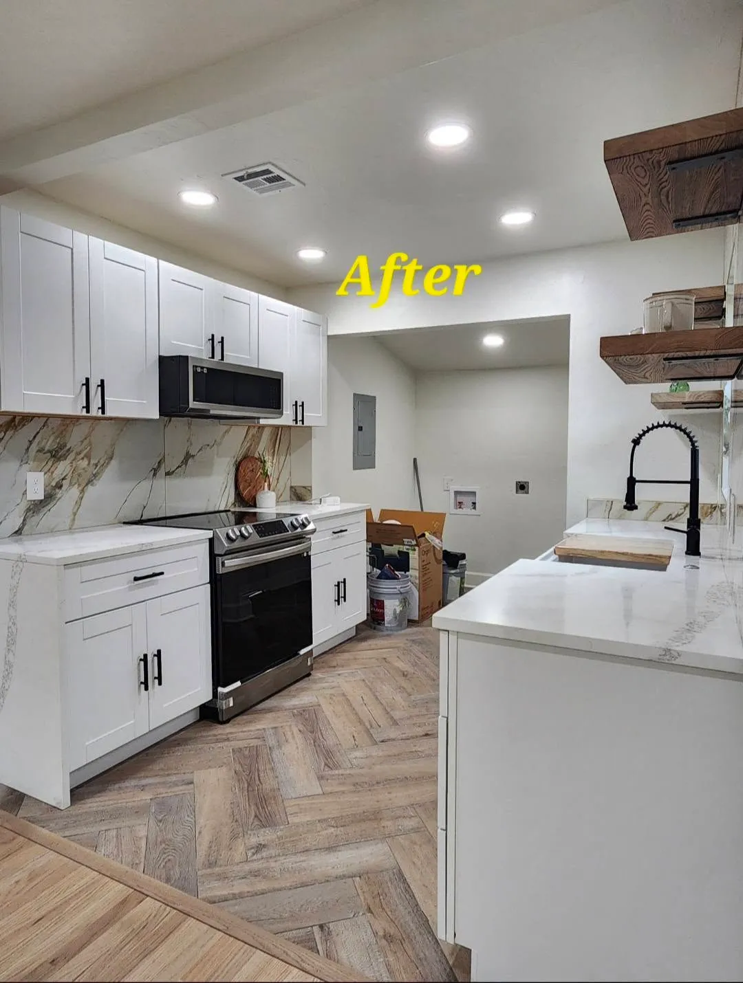 Same kitchen after rehab with white shaker cabinets, quartz counters and herringbone floors