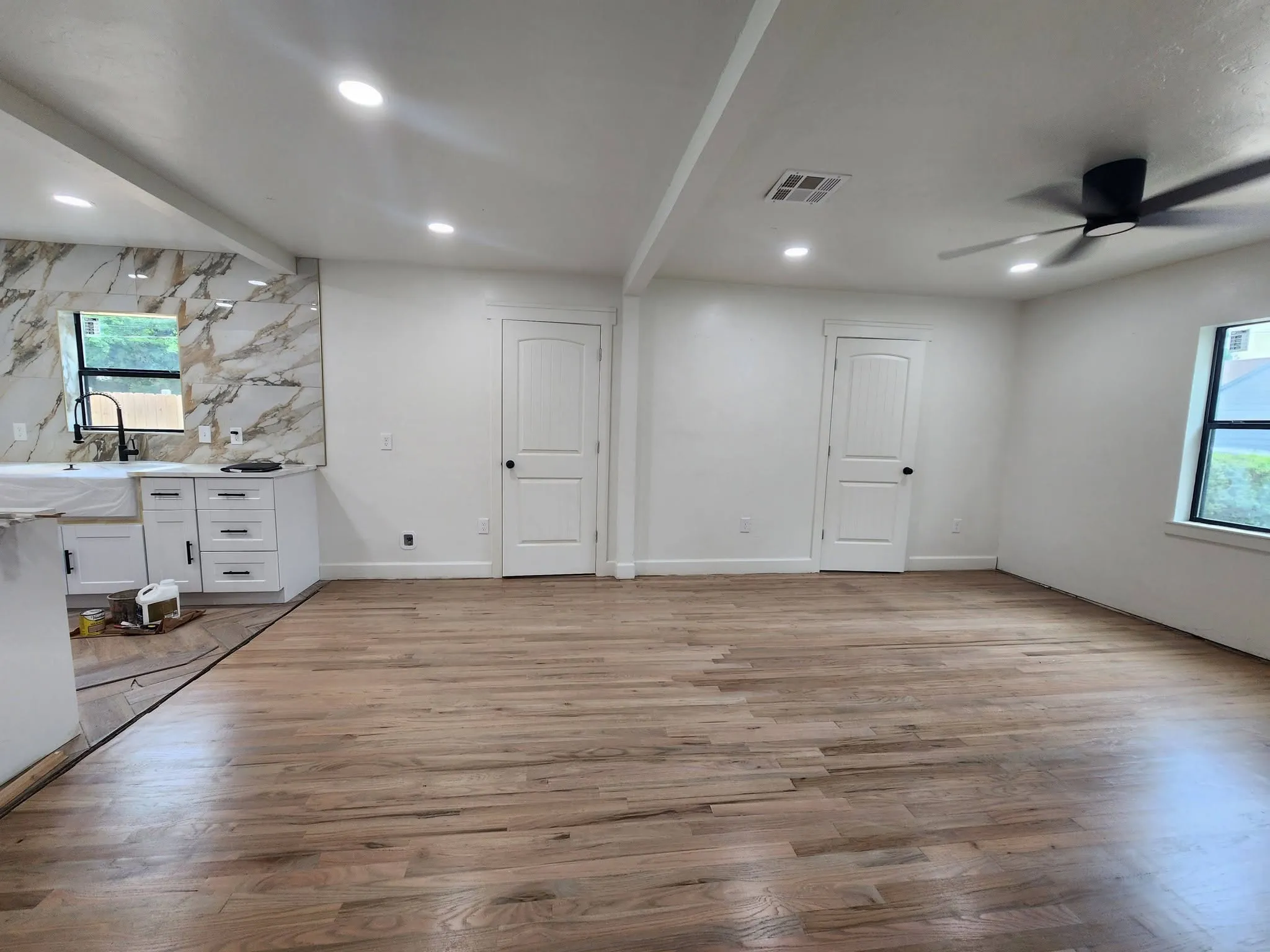 Renovated open living area with refinished hardwood floors, recessed lights and a new kitchen